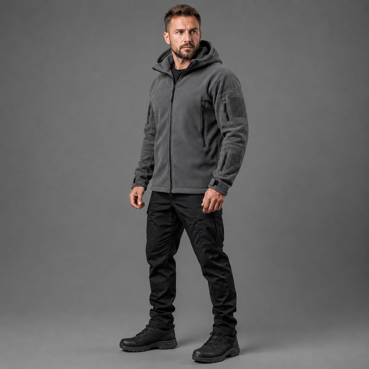 Man wearing gray tactical thermal fleece jacket in full-body studio view