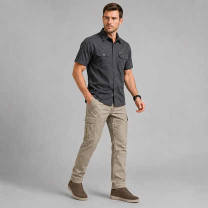 Man wearing the Charcoal short sleeve utility shirt with beige cargo trousers and casual taupe sneakers